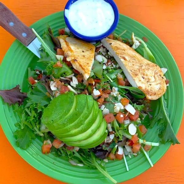 Loco Charlies' chicken salad with avocado, pico de gallo, and a side of dressing.
